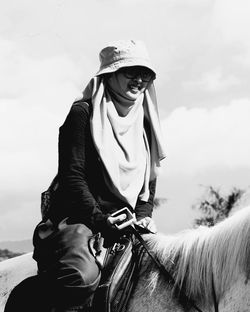 Mid adult man riding hat against sky