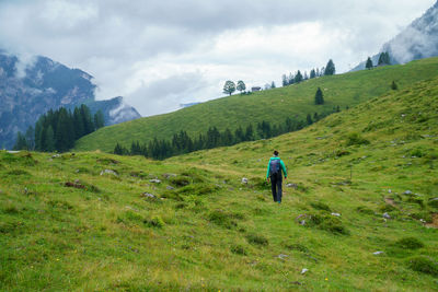 Rear view of woman on landscape against sky