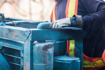 Midsection of mechanic repairing machinery