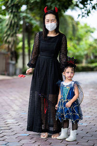 Mother and little girl in halloween costume standing outdoor