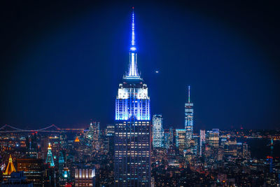 Illuminated cityscape against sky at night