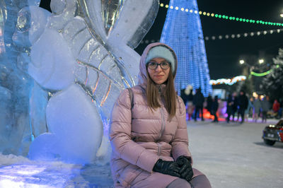 Portrait of young woman standing in city