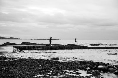 Scenic view of beach against cloudy sky