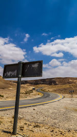 View of road sign against cloudy sky