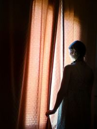Woman standing by window at home