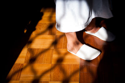 Low section of woman standing on hardwood floor