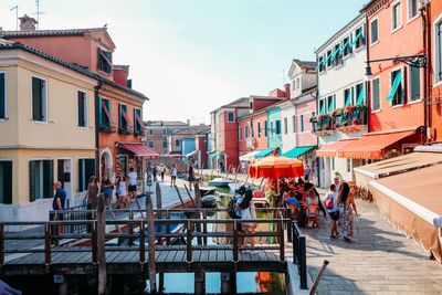 People walking on street amidst buildings in city