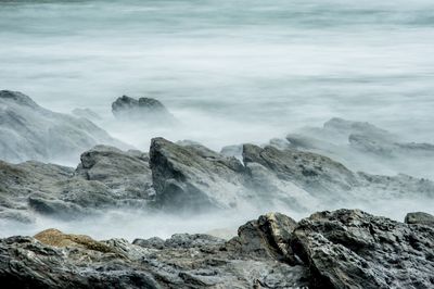 Scenic view of sea waves rushing towards rocks