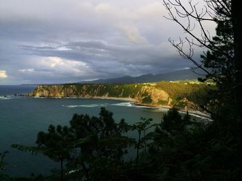 Scenic view of sea and mountains against sky