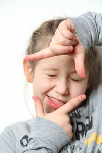 Close-up of girl gesturing over white background