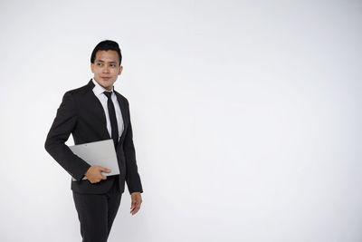 Portrait of man standing against white background