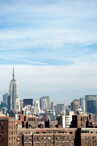 View of cityscape against cloudy sky