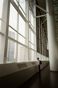 Side view of a man looking through window