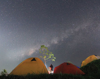 Low angle view of men standing against star field