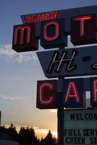 Low angle view of road sign against sky