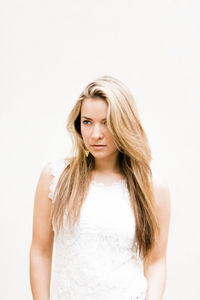 Portrait of beautiful young woman against white background