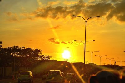 Silhouette street against sky during sunset