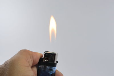 Close-up of hand holding burning candle