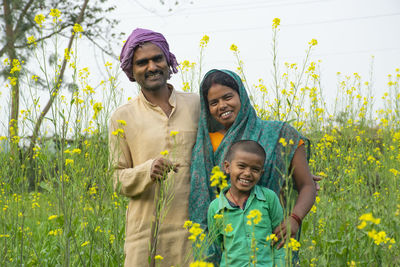 Portrait of a smiling young man against yellow plants