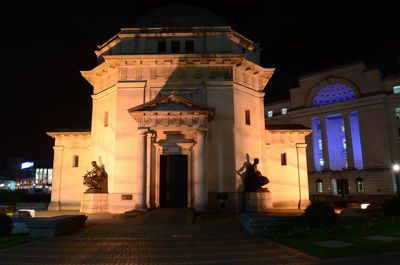 Statue in illuminated city at night