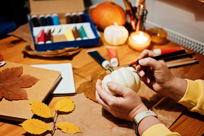 Autumn thanksgiving pumpkins craft. diy fall crafts for adults. female hands draw patterns on white