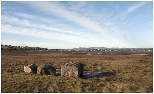Hay bales on field against sky