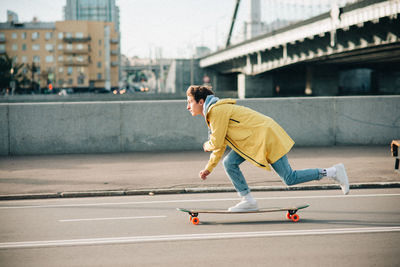 Side view of man running on bridge