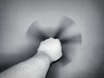Close-up of person holding hands against wall