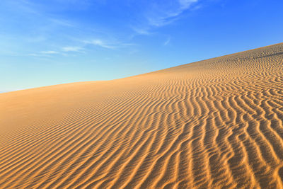 Scenic view of desert against blue sky