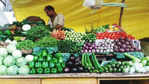 Vendor selling various vegetables at market