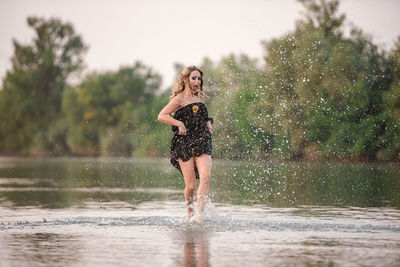 Full length of woman standing in water