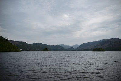 Scenic view of lake by mountains against sky