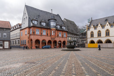 Buildings in city against cloudy sky