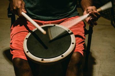 Midsection of man playing drum