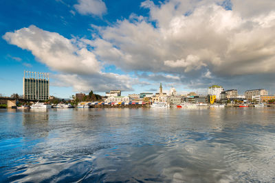 Buildings by sea against sky