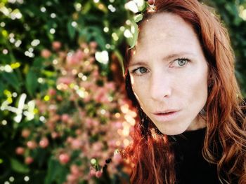 Close-up of thoughtful woman standing by plant