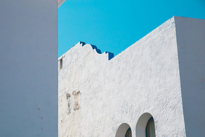 Low angle view of white building against blue sky