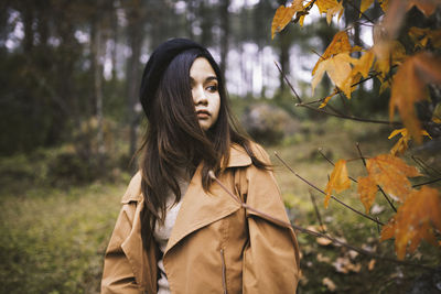 Woman standing by plant during autumn