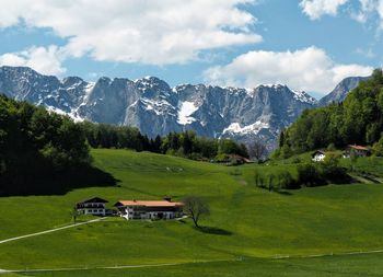 Scenic view of grassy field against cloudy sky