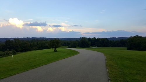 Scenic view of grassy field against cloudy sky