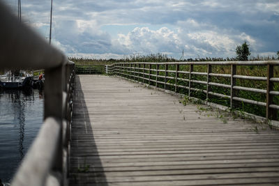 Footbridge over pier against sky