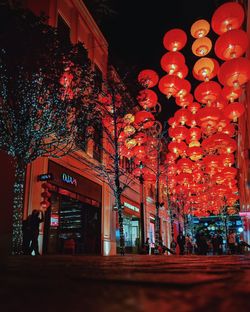 Low angle view of illuminated lanterns by building at night
