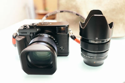 Close-up of digital camera with lens on table