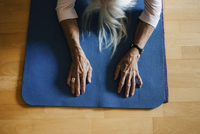 High angle view of senior woman exercising on mat at home