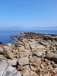 Rocks on beach against clear sky