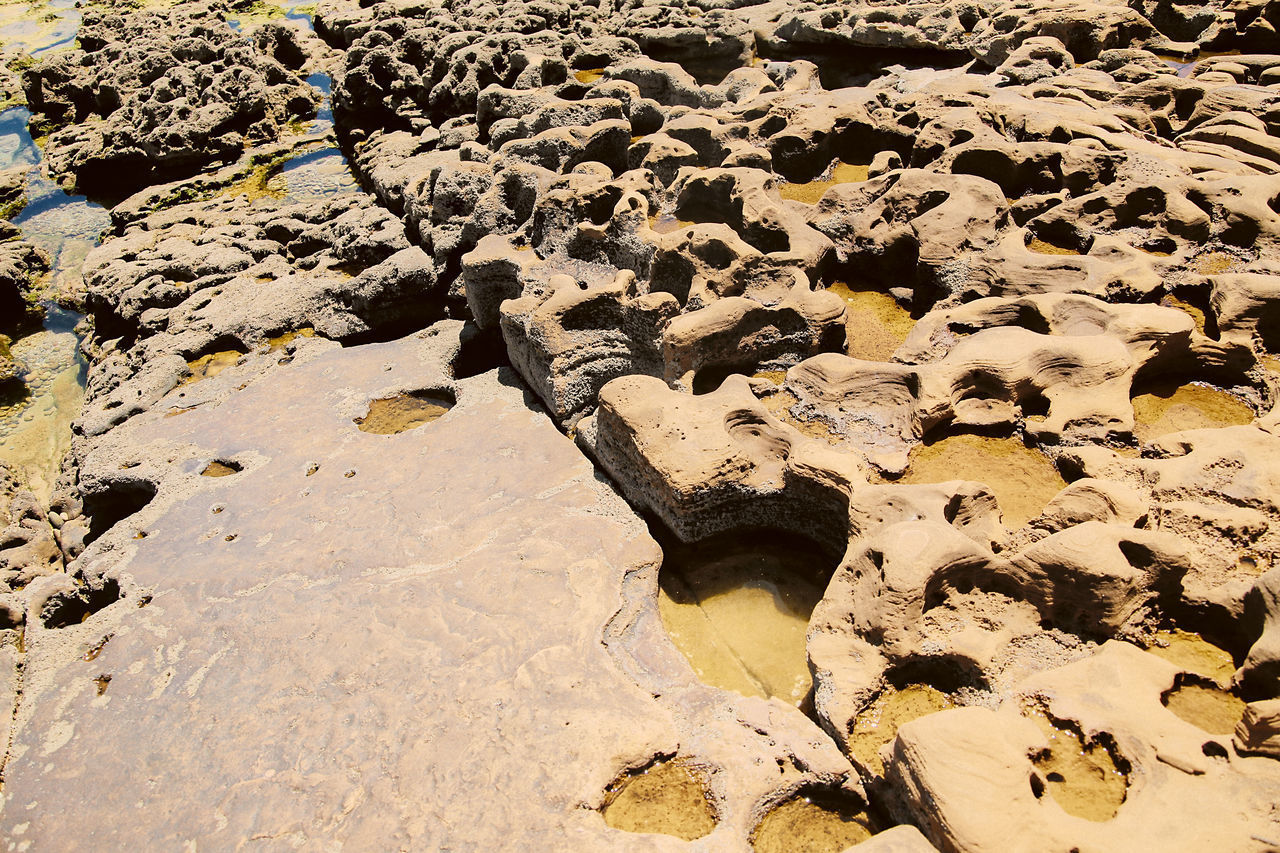 HIGH ANGLE VIEW OF ROCKS ON SHORE AT BEACH