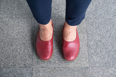 Low section of woman wearing shoes standing on floor