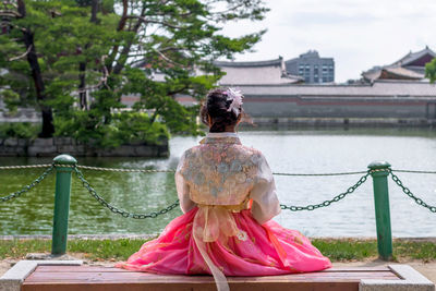 Rear view of woman sitting outdoors