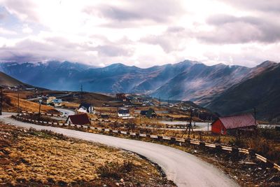 Road by illuminated mountains against sky at night