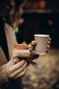 Midsection of woman holding coffee